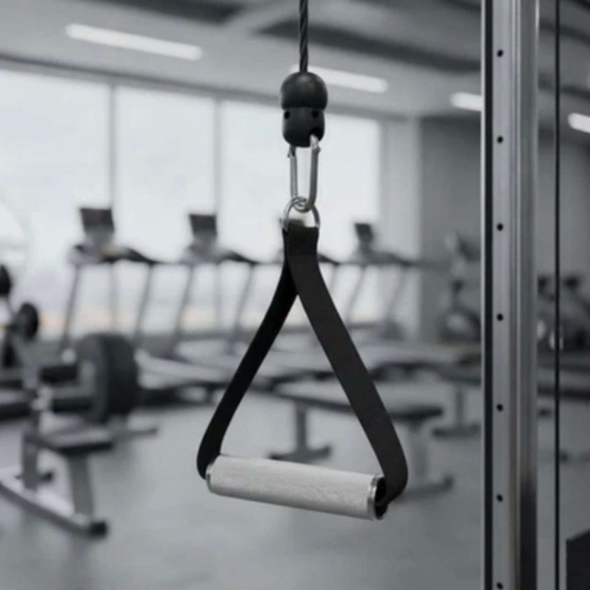 Gymless premium aluminium single cable handle with textured grip and black nylon strap attached to a gym pulley system
